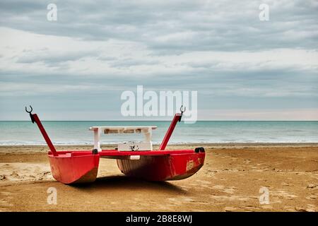 Rotes Sicherheitsboot - Katamaran am Meer am Strand in Rimini, Italien - Seascape Stockfoto