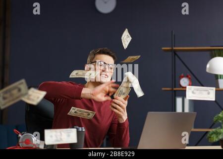 Ich bin reich. Portrait eines jungen Freiberuflers oder Geschäftsmannes im Hom Stockfoto