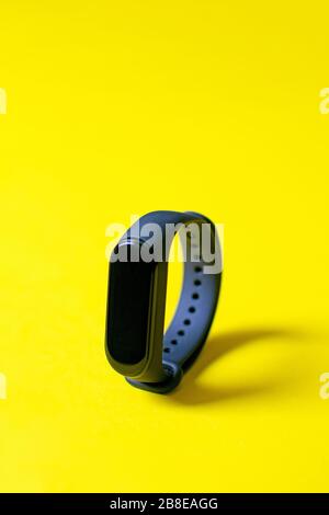 Klassisches blaues Fitness-Armband für Sporttraining auf hellgelbem Hintergrund. Selektiver Fokus. Stockfoto