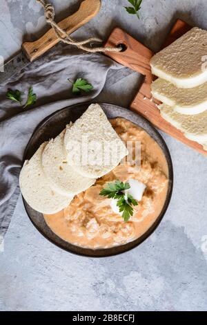 Klassischer ungarischer Szegedin-Schweinegulash mit Knödel auf Keramikplatte Stockfoto