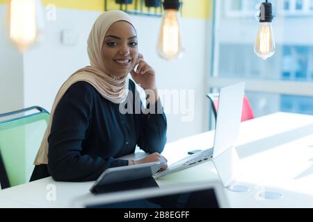 Junge muslimische afroamerikanische Geschäftsfrau als Führungskraft am Arbeitsplatz. Teamarbeit und multiethnisches Konzept. Glücklicher erfolgreicher Business Leader, der bei ihr arbeitet Stockfoto
