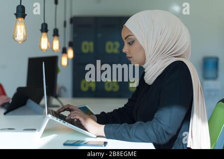 Junge muslimische afroamerikanische Geschäftsfrau als Führungskraft am Arbeitsplatz. Teamarbeit und multiethnisches Konzept. Glücklicher erfolgreicher Business Leader, der bei ihr arbeitet Stockfoto