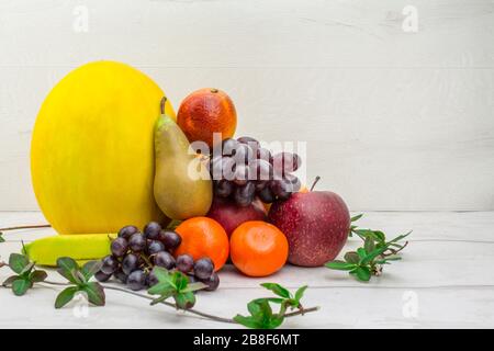 Obstkorb auf weißem Grund Melonenbirnen, Orangen, Trauben, apfel, Mandarine Stockfoto