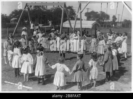 Mädchen Ausweichen Ballspiel auf Schulspielplatz. Mädchen stehen im Kreis und Mädchen im mittleren Halteball Stockfoto