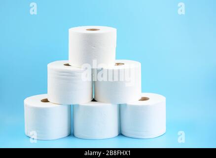 Toilettenpapier stapelte Rollen auf blauem Hintergrund.Toilettenpapierkrise durch Coronavirus COVID-19 Quarantäne. Kopierbereich. Stockfoto