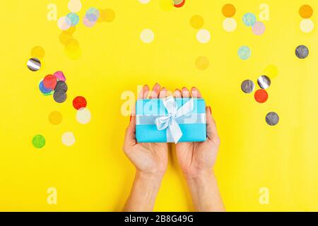 Geschenkschachtel handfest auf gelbem Hintergrund Stockfoto