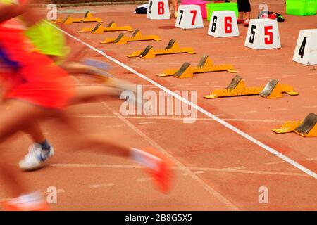 Der Start in der Sportversammlung beginnen die Athleten zu laufen Stockfoto