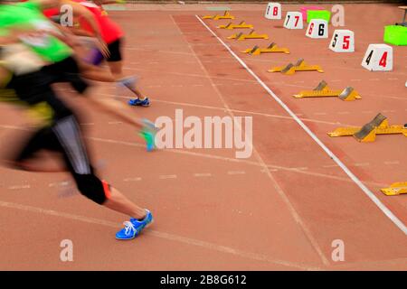 Der Start in der Sportversammlung beginnen die Athleten zu laufen Stockfoto