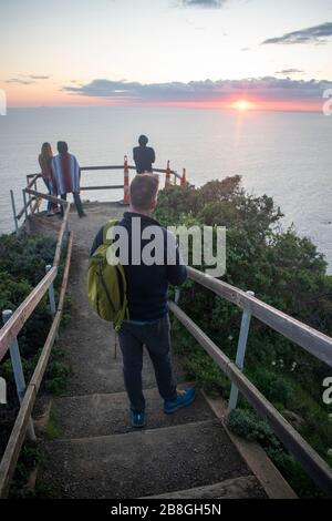 Die Menschen versammeln sich am Muir Beach mit Blick auf Marin County, Kalifornien, um den Sonnenuntergang zu beobachten. Stockfoto
