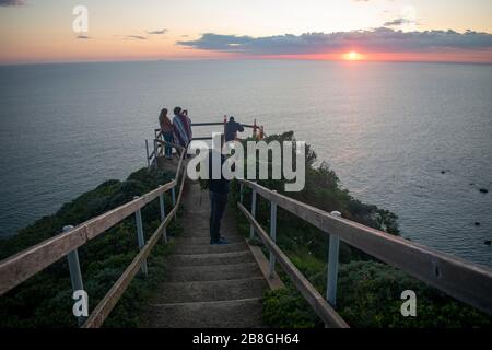 Die Menschen versammeln sich am Muir Beach mit Blick auf Marin County, Kalifornien, um den Sonnenuntergang zu beobachten. Stockfoto