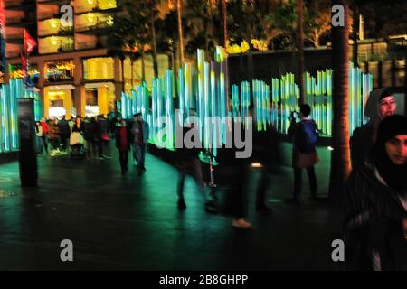 Menschen, die eine Lichtskulptur im VIVID Sydney, Circular Quay, passieren; das beliebte jährliche Ereignis von Licht und kreativer illuminierter Kunst Stockfoto