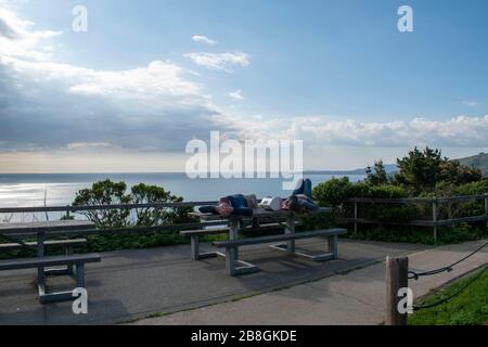 Ein Paar nimmt ein Nickerchen auf einem Picknicktisch am Muir Beach Overlook in Marin County, CA. Stockfoto