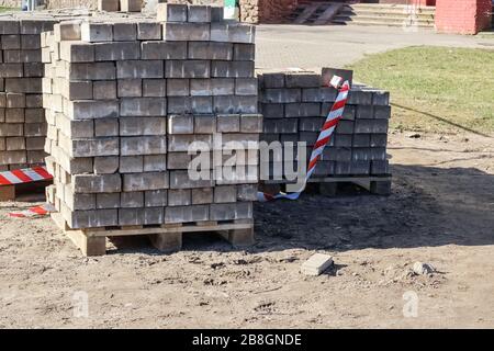 Pflastersteine auf einer Holzpalette auf Gras Stockfoto