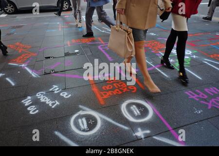 Frauen, Schuhe und Beine laufen über mehrfarbige Straßenpflaster in Rot, weiß, Lila und Grün auf grauen Steinpflastern in Sydney Stockfoto