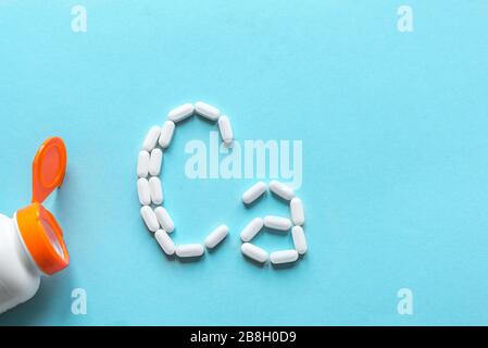 Kalziumtabletten. Weiße Pillen, die Form eines Ca-Alphabets auf blauem Hintergrund bilden, Kopierbereich, Draufsicht. Stockfoto