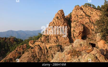 Panorama der Straße D81 auf Korsika Frankreich und der roten Felsen bei Sonnenuntergang Stockfoto