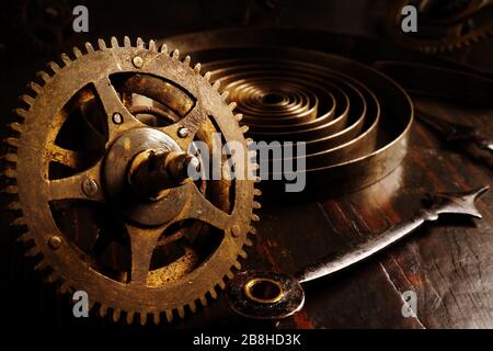 Nahaufnahme alter Uhrengetriebe. Dunkler Hintergrund mit Retro-Uhr als Zeitkonzept. Stockfoto