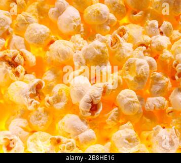 Haufen frischen Popcorns, der den Rahmen gegen helles Licht füllt Stockfoto