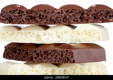 Stapel von brauner und weißer poröser Schokolade isoliert auf dem weißen Hintergrund Stockfoto