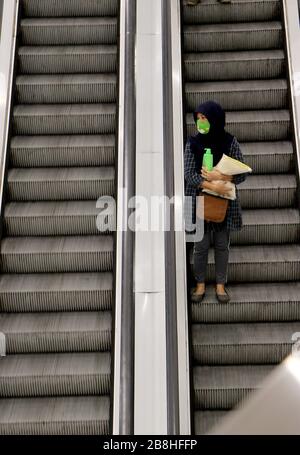 Bangkok, Thailand. März 2020. Eine Frau trägt Reispack, während sie Rolltreppe nimmt, nachdem Bangkok Metropolitan Administration die vorübergehende Schließung im Einkaufszentrum in Bangkok am 22. März 2020 angeordnet hat. Die Bangkok Metropolitan Administration hat die vorübergehende Schließung vieler Orte angeordnet, die sie für ein hohes Risiko für eine Covid-19-Infektion in der Hauptstadt vom 22. März bis 12. April hält. Kredit: Urdee Image/ZUMA Wire/Alamy Live News Stockfoto