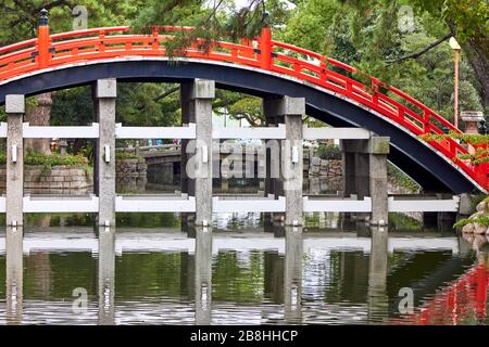 Rote Brücke über den Teich auf japanischem Schreingelände Stockfoto