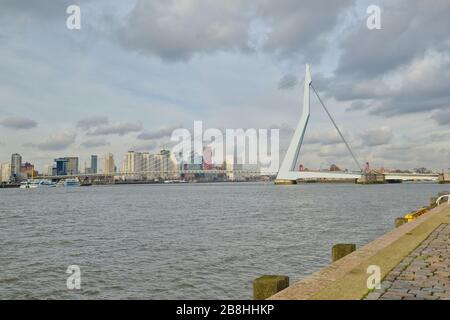 Rotterdam - 12. Februar 2019: Rotterdam, die Skyline der niederländischen Innenstadt in der Dämmerung in Südholland, Rotterdam, Niederlande. Rechts die Erasmus-Brücke Stockfoto