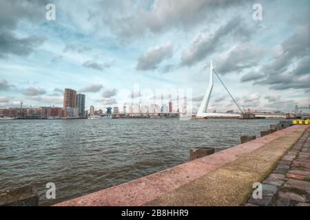 Rotterdam - 12. Februar 2019: Rotterdam, die Skyline der niederländischen Innenstadt in der Dämmerung, Straße im Vordergrund, Südholland, Rotterdam, Niederlande. Stockfoto