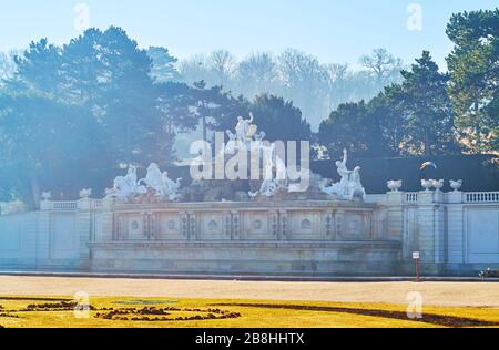 WIEN, ÖSTERREICH - 19. FEBRUAR 2019: Der leichte morgendliche Winternebel über dem Meisterwerk Neptun Brunnen von Schloss Schönbrunn, am 19. Februar in Wien Stockfoto