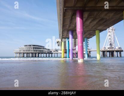 Regenbogen farbige Steinpfosten unter dem Pier von scheveningen Strand Niederlande mit Sand und Wellen im Meer, Scheveningen, Niederlande Stockfoto