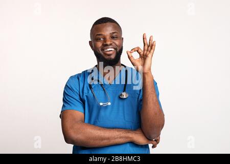 Afrikanischer Arzt, der seine Klinik über weißen Hintergrund empfahl Stockfoto