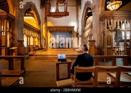 ERNEUTER WEGGANG DER FREMDEN ZEILE AM UNTEREN RAND DER BILDUNTERSCHRIFT EIN Gemeindemitglied der Kirche beobachtet einen Laptop in der Liverpool Parish Church (Our Lady and St Nicholas) in Liverpool während des ersten virtuellen Sonntagsgottesdienstes der Kirche von England, den der Erzbischof von Canterbury Justin Welby gegeben hat, Nachdem die Erzbischöfe von Canterbury und York am Dienstag an Geistliche geschrieben hatten, um ihnen zu raten, öffentliche Dienste in die Warteschleife zu stellen, um auf Regierungsratschläge zu reagieren, um Massenversammlungen zu vermeiden, um die Ausbreitung des Covid-19-Virus zu verhindern. Stockfoto