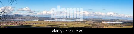 Panoramasicht auf die Landschaft mit Forggensee und Bannwaldsee von Schloss Neuschwanstein an einem sonnigen Wintertag mit blauer Himmelswolke in Backgroun Stockfoto