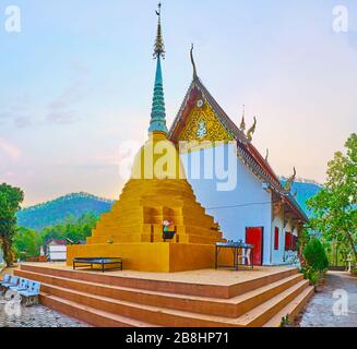 Der vergoldete Chedi mit kunstvollen Hti-Regenschirm, der sich hinter dem Ubosot (ordination Hall) des Wat Phra that Mae Yen Temple, Pai, Thailand befindet Stockfoto