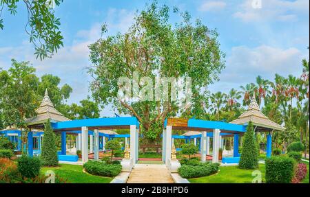 Panorama der Gartenpavillons der neuen Theorie, dekoriert mit großem ausgebreiteten Baum und Skulpturen von Devata-Götter am Eingang, Rajapruek-Park, Chiang Mai Stockfoto