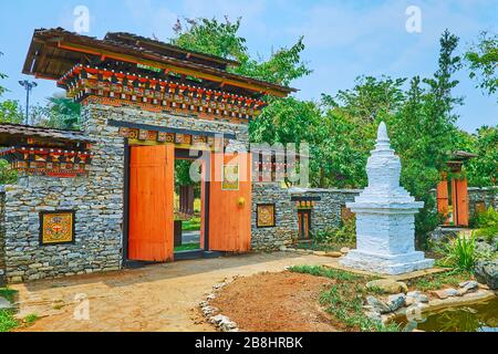 Die traditionelle bhutanische Architektur schmückt den bhutanischen Garten des Rajapruek-Parks; die weißen Ziegelchorten (Stupa) sind mit Steinmauer und Ca umgeben Stockfoto