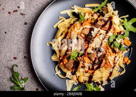 Bolognese Pasta mit Champignons und Arugula zubereitete Balsamiksoße. Nahaufnahme. Draufsicht. Stockfoto