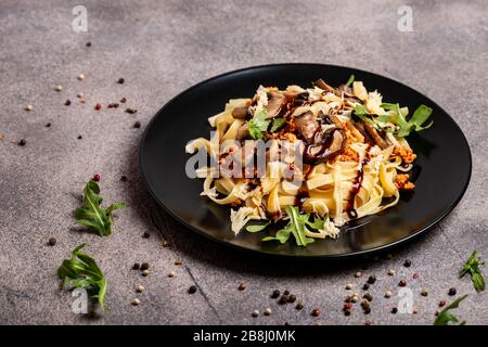 Bolognese Pasta mit Champignons und Arugula zubereitete Balsamiksoße. Stockfoto