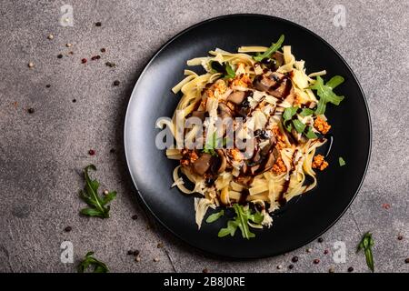 Bolognese Pasta mit Champignons und Arugula zubereitete Balsamiksoße. Draufsicht. Platz für Text kopieren. Stockfoto