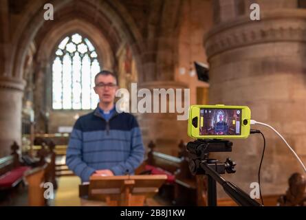 Rector Rob Miles hält seine Predigt während einer Live-Übertragung des Sonntagsgottesdienstes in der St Lukes Church in Thurnby, Leicester, Nachdem die Erzbischöfe von Canterbury und York am Dienstag an Geistliche geschrieben hatten, um ihnen zu raten, öffentliche Dienste in die Warteschleife zu stellen, um auf Regierungsratschläge zu reagieren, um Massenversammlungen zu vermeiden, um die Ausbreitung des Covid-19-Virus zu verhindern. Stockfoto