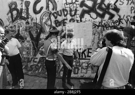 Die Militärpolizei greift während eines Protestes an einem Abschnitt der Berliner Mauer am Brandenburger Tor, West-Berlin, ein. Die Berliner Mauer war eine von der Deutschen Demokratischen Republik (DDR, Ostdeutschland) am 13. August 1961 errichtete Barriere, die West-Berlin von der umliegenden DDR und von Ost-Berlin völlig abgrenzte. Die Mauer wurde am 9. November 1989 die freie Personenbewegung von Ost nach West erlaubt. Stockfoto
