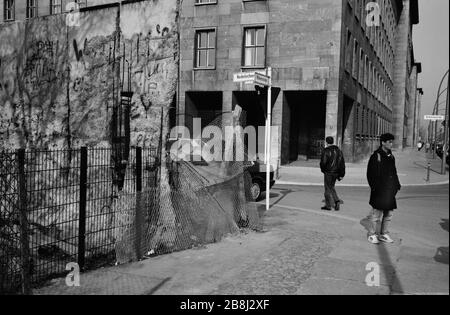 Menschen, die die frühere Linie der Berliner Mauer an der Wilhelm Straße in der Innenstadt überqueren. Die Berliner Mauer war eine von der Deutschen Demokratischen Republik (DDR, Ostdeutschland) am 13. August 1961 errichtete Barriere, die West-Berlin von der umliegenden DDR und von Ost-Berlin völlig abgrenzte. Die Mauer wurde am 9. November 1989 die freie Personenbewegung von Ost nach West erlaubt. Stockfoto