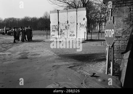 Touristen, die ruinierte Abschnitte der ehemaligen Berliner Mauer am Potsdamer Platz betrachten, wo die Mauer zuvor verlaufen war. Die Berliner Mauer war eine von der Deutschen Demokratischen Republik (DDR, Ostdeutschland) am 13. August 1961 errichtete Barriere, die West-Berlin von der umliegenden DDR und von Ost-Berlin völlig abgrenzte. Die Mauer wurde am 9. November 1989 die freie Personenbewegung von Ost nach West erlaubt. Stockfoto