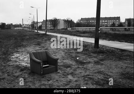 Ein verlassenes Sofa neben einem Fußgängerbereich im Verlauf der ehemaligen Berliner Mauer, Bornholmer Straße, Berlin. Die Berliner Mauer war eine von der Deutschen Demokratischen Republik (DDR, Ostdeutschland) am 13. August 1961 errichtete Barriere, die West-Berlin von der umliegenden DDR und von Ost-Berlin völlig abgrenzte. Die Mauer wurde am 9. November 1989 die freie Personenbewegung von Ost nach West erlaubt. Stockfoto