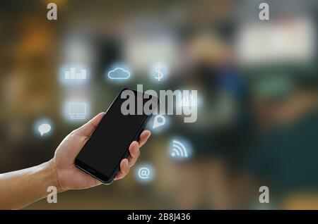 Handgehaltener Smartphone mit Icons Konzept. Stockfoto