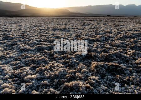 Afrika, Dschibuti, Assalsee. Salzstruktur auf dem Boden mit Bergen im Hintergrund Stockfoto