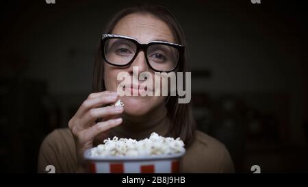Frau, die einen romantischen Film sieht und Popcorn isst Stockfoto