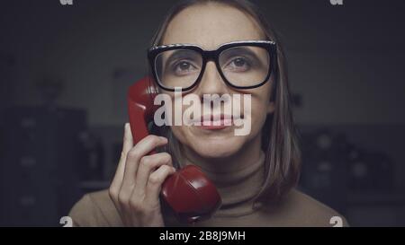 Enttäuschte Frau mit Brille, die einen langweiligen Telefonanruf hat Stockfoto