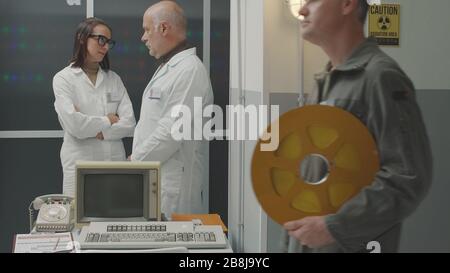 Wissenschaftliches Team im Vintage-Stil, das im Labor arbeitet und gemeinsam diskutiert Stockfoto