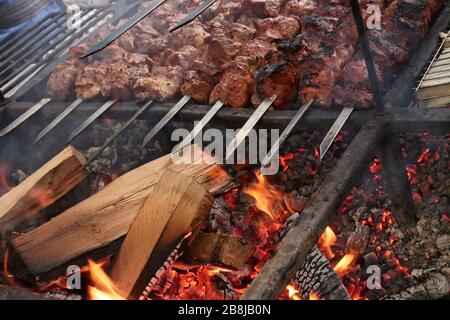 Fleischstücke werden auf Metallstäben über heißer Holzkohle aus nächster Nähe geröstet Stockfoto