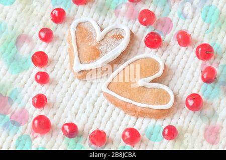 Liebeskonzept mit roten Beeren in Form von Herz und Keksen in Form von Herz auf weiß gefundenem Hintergrund. Reife rote Beeren und Kuchen Stockfoto